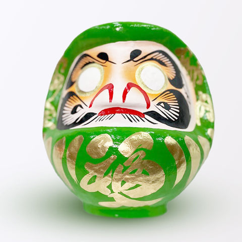 A 23-centimeter tall green Fuku-iri lucky daruma doll, made by Imai Daruma Naya, featuring a rotund body and decorative patterns for eyebrows and beard and gold body lines and kanji lettering.