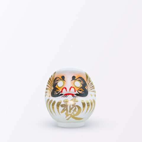 A 12-centimeter tall white Fuku-iri papier-mache daruma dolls, made by Imai Daruma Naya. All feature rotund bodies, decorative patterns for eyebrows and beards and gold body lines and kanji lettering.