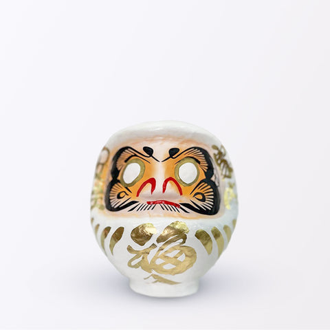 A 15-centimeter tall white Fuku-iri papier-mache daruma dolls, made by Imai Daruma Naya. All feature rotund bodies, decorative patterns for eyebrows and beards and gold body lines and kanji lettering.