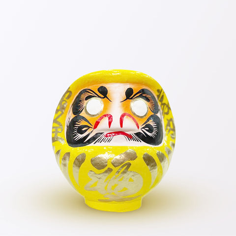 A 17-centimeter tall yellow Fuku-iri papier-mache daruma dolls, made by Imai Daruma Naya. All feature rotund bodies, decorative patterns for eyebrows and beards and gold body lines and kanji lettering.