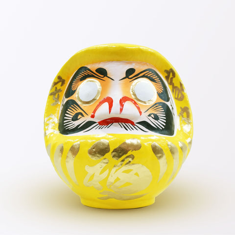 A 20-centimeter tall yellow Fuku-iri papier-mache daruma dolls, made by Imai Daruma Naya. All feature rotund bodies, decorative patterns for eyebrows and beards and gold body lines and kanji lettering.