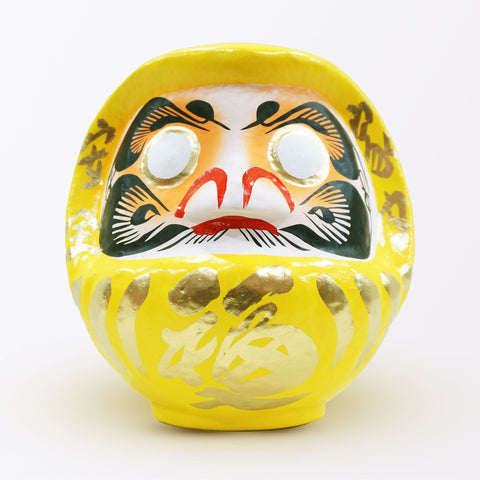 A 23-centimeter tall yellow Fuku-iri papier-mache daruma dolls, made by Imai Daruma Naya. All feature rotund bodies, decorative patterns for eyebrows and beards and gold body lines and kanji lettering.